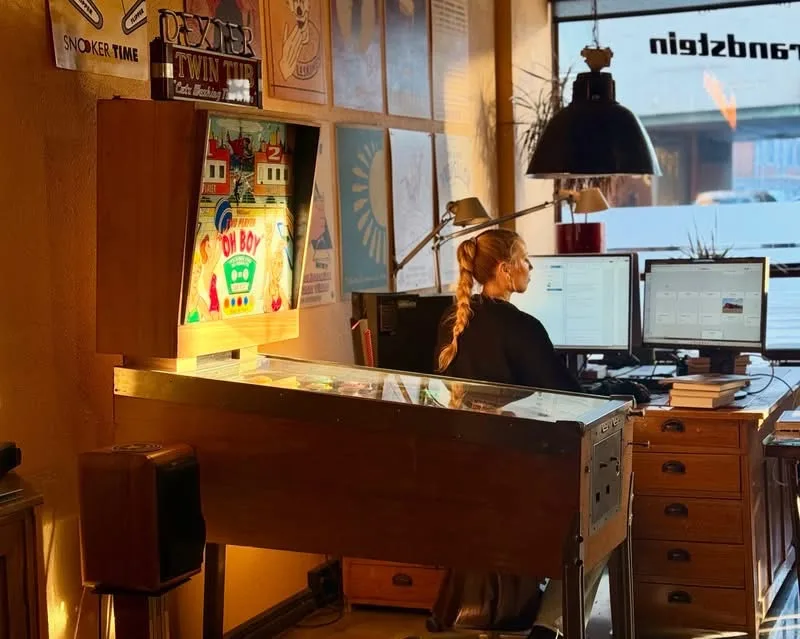 Jenna työskentelee flipperin vieressä