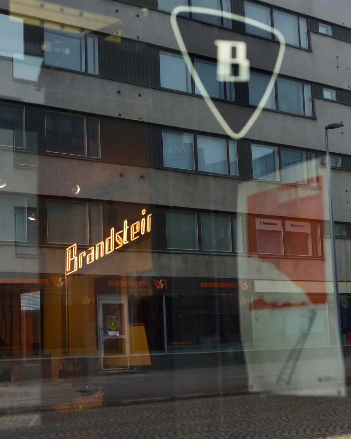 Brandstein-neon ja B-logo heijastuvat toimiston ikkunaan
