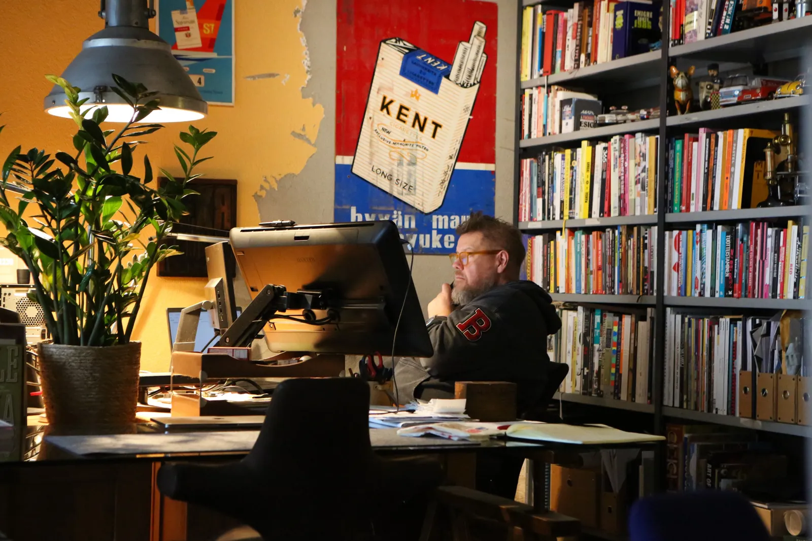 Tuomas työpöydän ääressä kirjahyllyjen keskellä